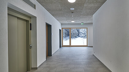 Erweiterungsbau Schule Haslach / Traunstein. Aufzug und Fenster im Flur