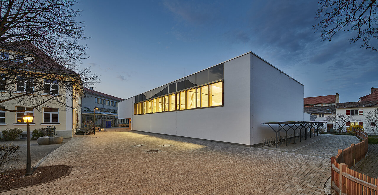Neubau Turnhalle Schloßberg: Außenansicht vom Pausenhof der Grundschule Schloßberg.  Fassade Nord