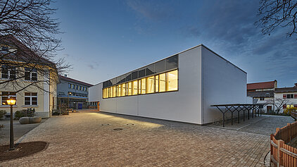 Neubau Turnhalle Schloßberg: Außenansicht vom Pausenhof der Grundschule Schloßberg.  Fassade Nord